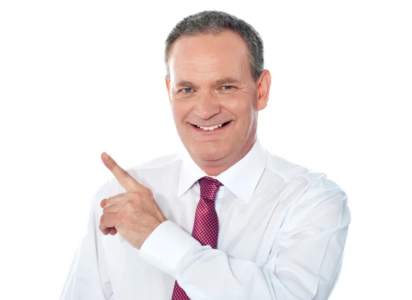 Smiling businessman pointing away — Stock Photo, Image