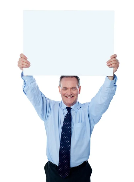Geschäftsmann hält eine leere Plakatwand über den Kopf — Stockfoto