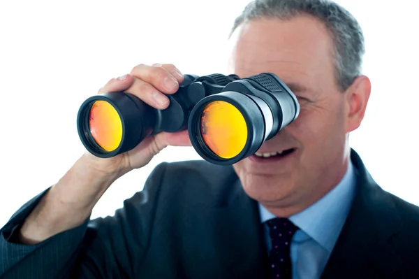 Senior man observing through binoculars — Stock Photo, Image