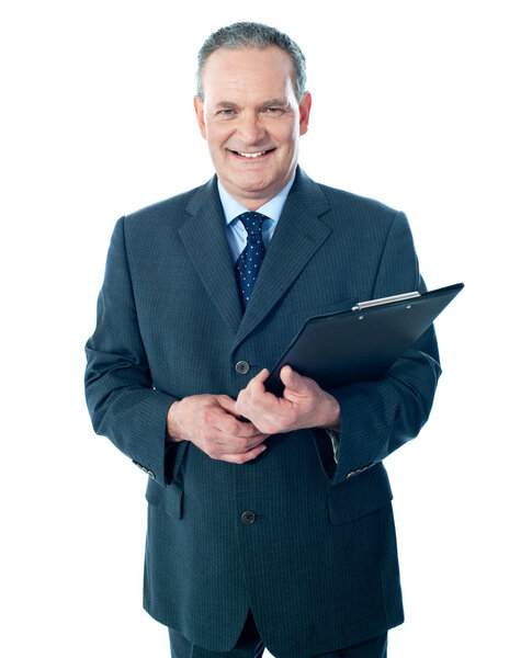 Smiling elderly businessman holding clipboard. Dressed in black suit