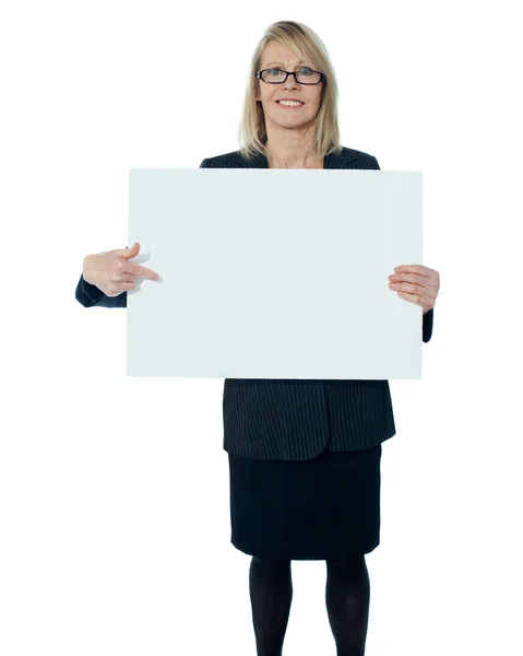 Mulher corporativa apontando para cartaz em branco — Fotografia de Stock