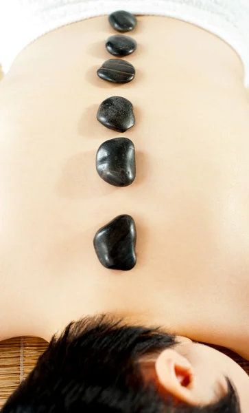 Nackte Frau bekommt Wellness-Behandlung mit heißen Steinen — Stockfoto