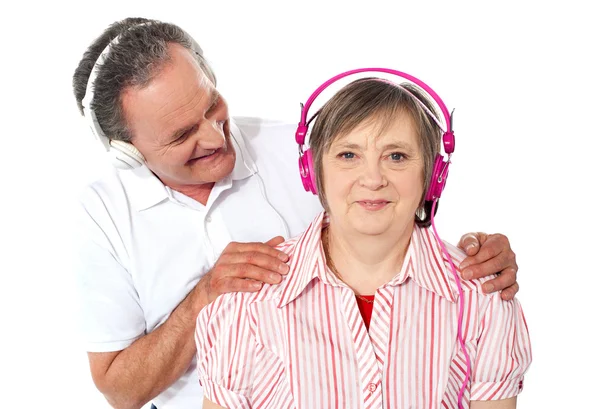 Casal idoso desfrutando de música sobre fundo branco — Fotografia de Stock