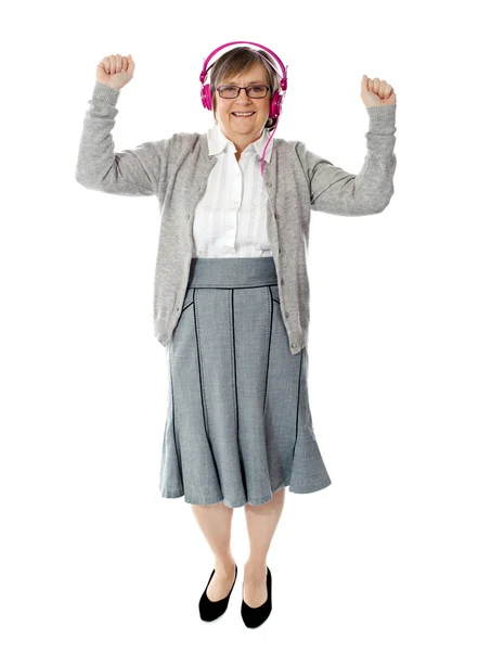 Glad äldre kvinna njuter musik — Stockfoto