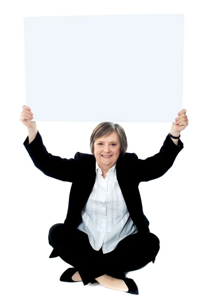 Seated businesswoman holding blank whiteboard — Stock Photo, Image