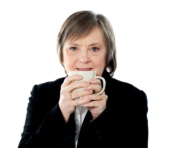 Old woman holding coffee mug — Stock Photo, Image