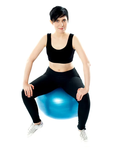 Young athlete sitting on a swiss ball Royalty Free Stock Photos