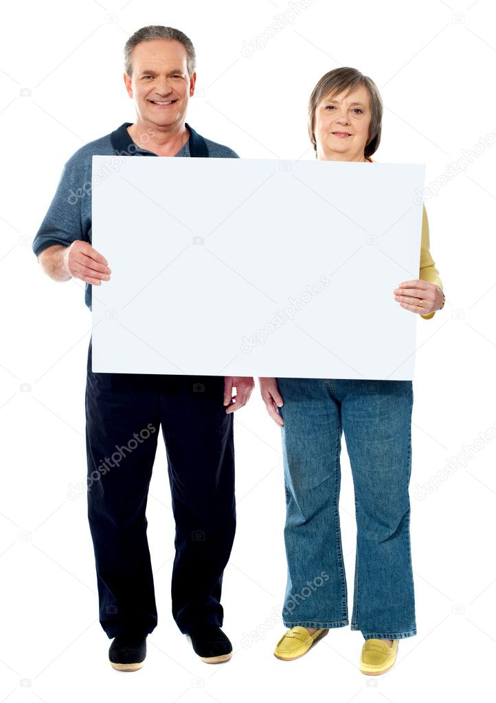 Happy senior couple holding a white placard