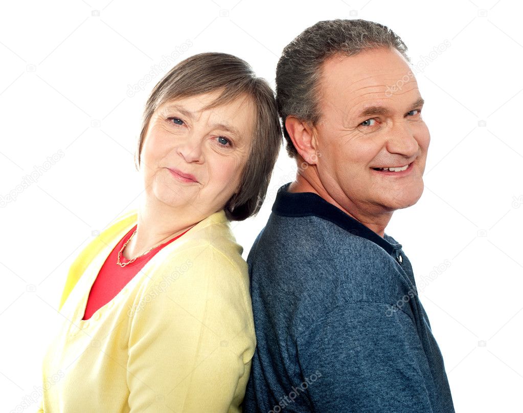 Portrait of senior couple back to back in studio