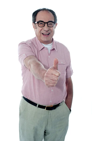 Lächelnder älterer Mann gestikuliert mit erhobenen Daumen — Stockfoto