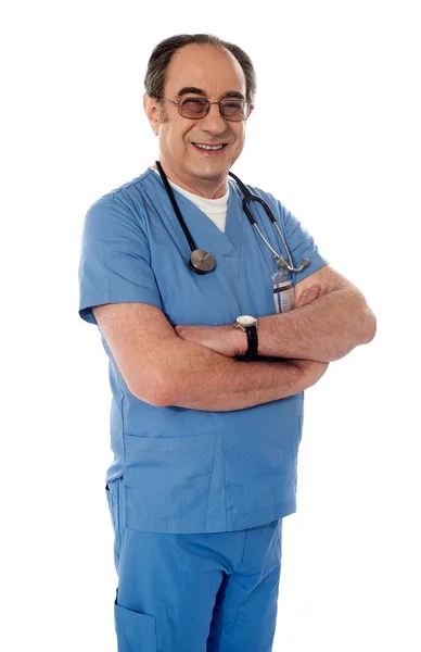 Усміхнений визрілий лікар позує складеними руками — стокове фото