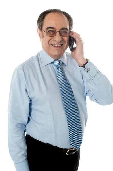 Un hombre de negocios sonriente atendiendo llamadas telefónicas — Foto de Stock