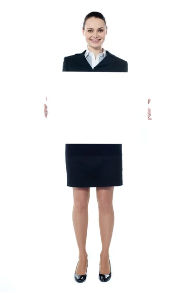 Caucasian businesswoman holding a blank billboard — Stock Photo, Image