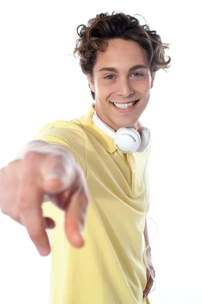 Хлопець з навушниками вказує на вас — стокове фото