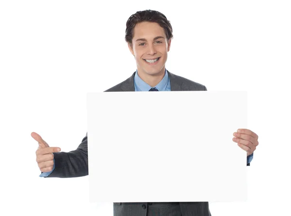 Executivo masculino apontando para cartaz em branco — Fotografia de Stock