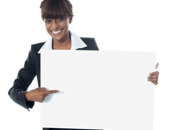 Ejecutiva femenina corporativa apuntando hacia banner en blanco — Foto de Stock
