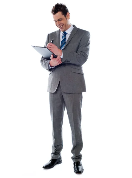 Hombre de negocios exitoso escribiendo notas en el portapapeles — Foto de Stock