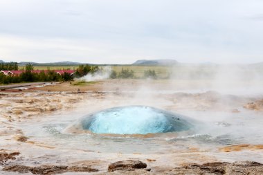 The Strokkur geyser about to erupt clipart