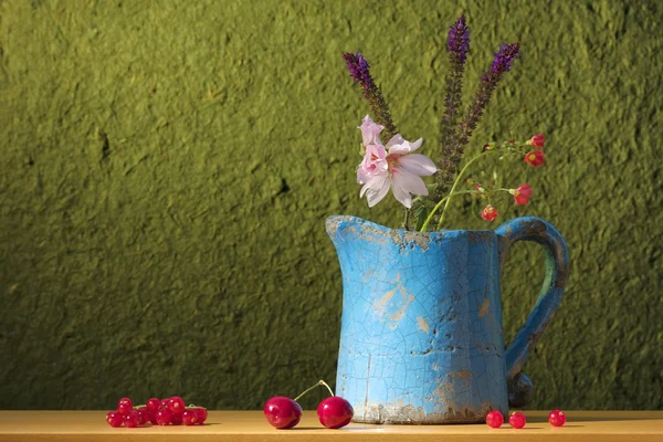 Ainda vida com uma lata com flores, cerejas e ber vermelho — Fotografia de Stock