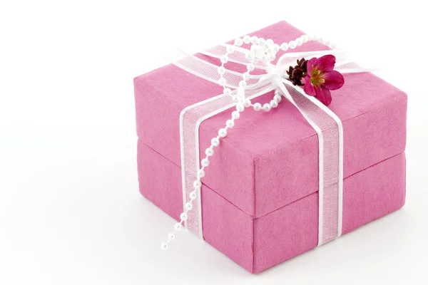 Rózsaszín ajándék doboz-val a szalag és a kis virág — Stock Fotó
