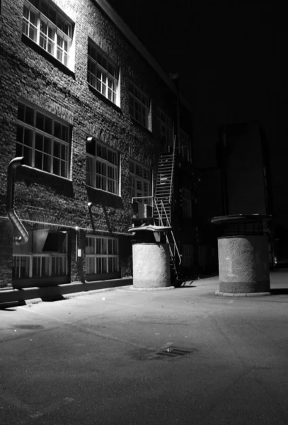 暗い路地、工場の裏庭、黒と白 ロイヤリティフリーのストック画像