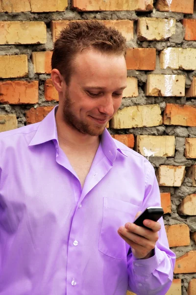 Biznesmen przy jego sellphone budowlane — Zdjęcie stockowe