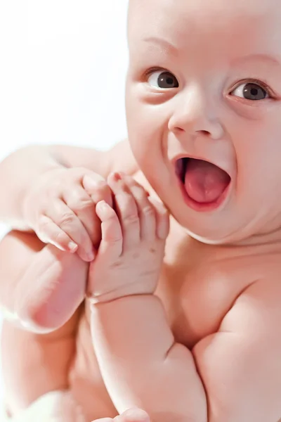 Boldog baba játék a kezek és a lábak fehér háttér — Stock Fotó
