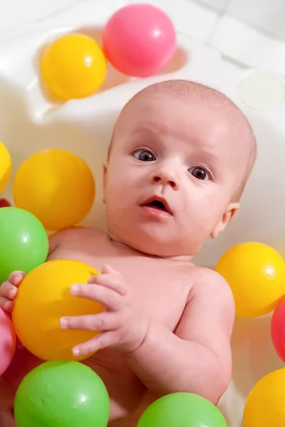 Little baby having a bath with colorful balls — Stock Photo, Image