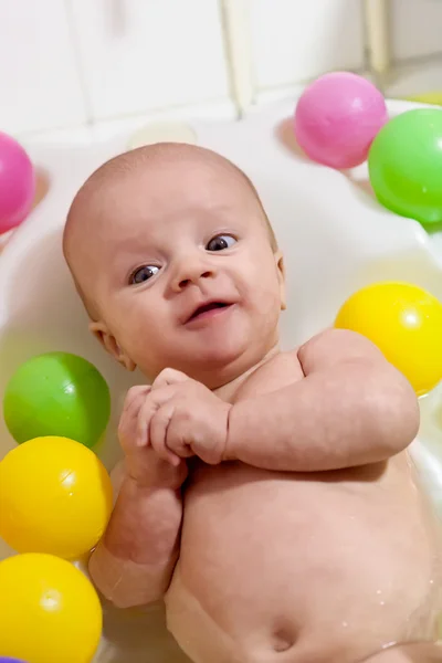 Pequeno bebê tendo um banho com bolas coloridas — Fotografia de Stock