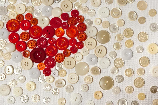 Colorful buttons in shape of heart on white fabric — Stock Photo, Image