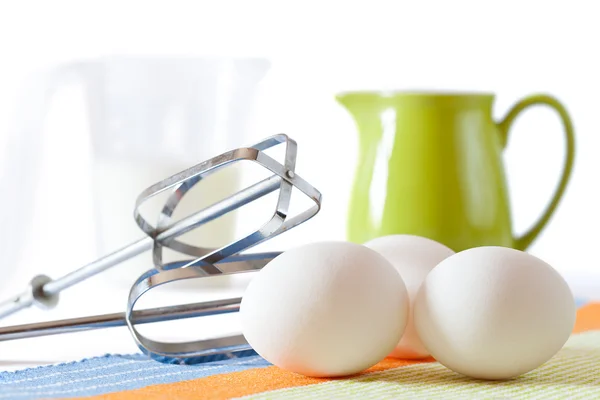 Cookies making: fresh eggs, green jug, milk and mixer isolated — Stock Photo, Image