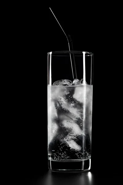Vidro de água e gelo sobre fundo preto — Fotografia de Stock