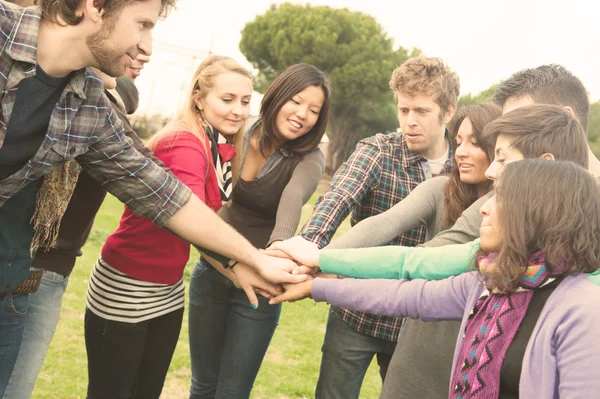 Studenti multirazziali con mani sulla pila — Foto Stock