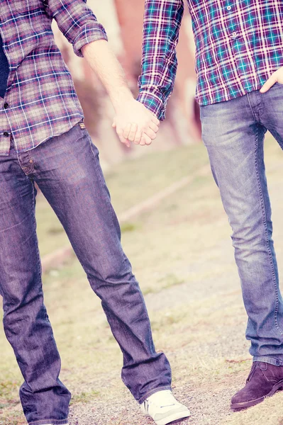 Pareja gay outdise celebración de manos — Foto de Stock
