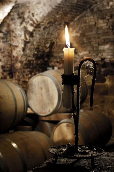 stock image Old candle in a wine barrel cellar