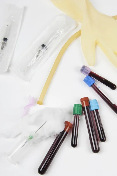 Test tubes with blood samples and with how many and syringe — Stock Photo, Image