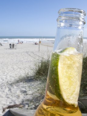 Bottle of Beer with Lime on the Beach