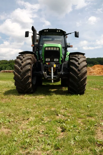 Зеленый трактор на траве — стоковое фото