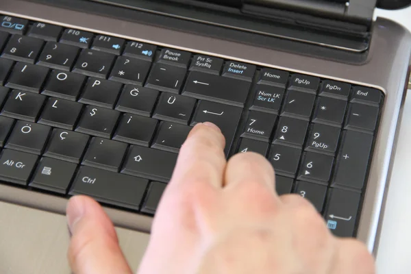 手指上的使用一台笔记本电脑，输入按钮 — 图库照片