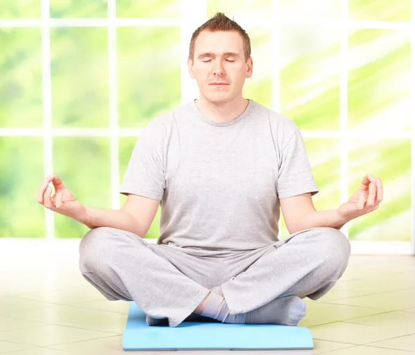 Člověk dělá jóga cvičení na podložce — Stock fotografie