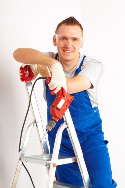 Man with drill standing on ladder clipart