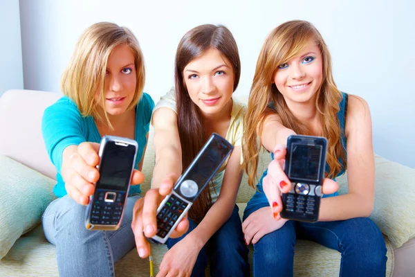 Drie meisjes met mobiele telefoons — Stockfoto