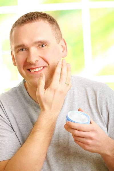 男の顔のクリームを適用します。 — ストック写真