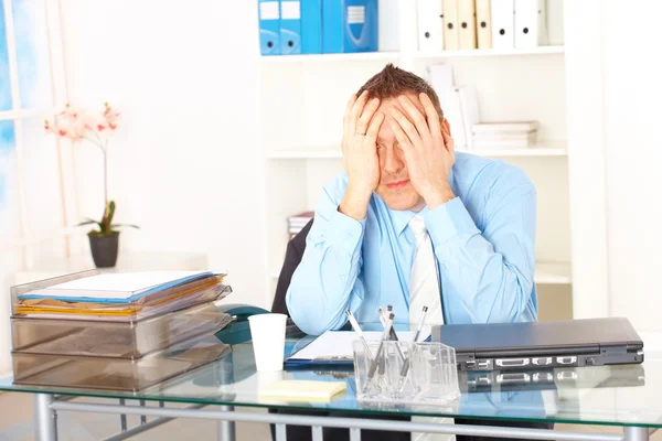 Gestresster Geschäftsmann sitzt am Schreibtisch — Stockfoto