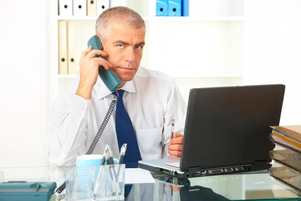 Affärsman med telefon och laptop — Stockfoto