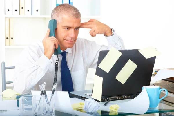 Stressad affärsman som sitter vid skrivbord — Stockfoto
