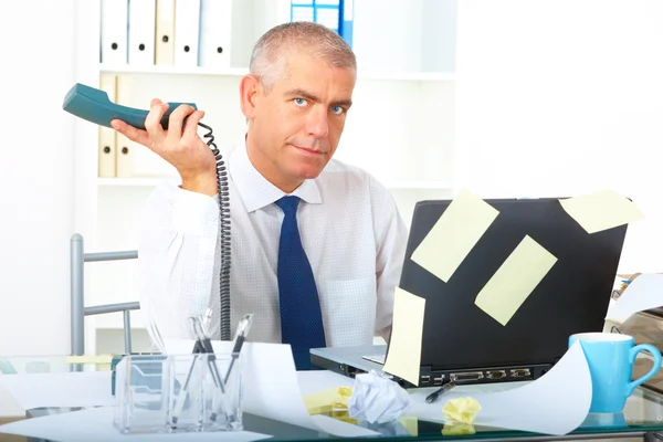 Hombre de negocios estresado sentado en el escritorio —  Fotos de Stock