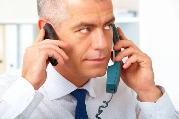 Geschäftsmann mit zwei Telefonen — Stockfoto