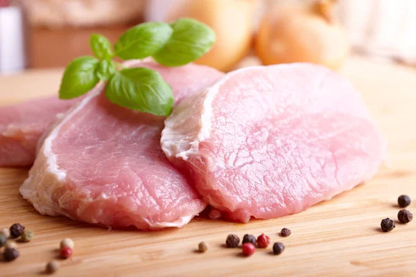 Raw pork chops on cutting board — Stock Photo, Image