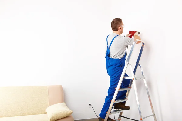 Man with drill working on ladder — Stock Photo, Image